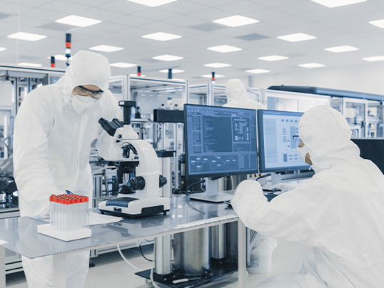Biotechnologische Forschung im Reinraumlabor Zwei Wissenschaftler in Schutzkleidung arbeiten im Hightech-Labor