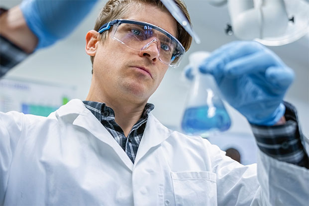 Chemische Analyse und Forschung im Labor Wissenschaftler im Labor analysiert Flüssigkeit im Erlenmeyerkolben