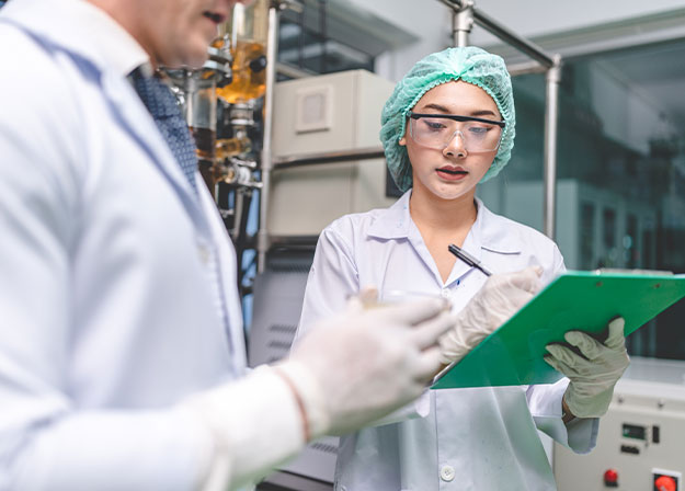 Eine Fachkraft dokumentiert regulatorische Informationen und stimmt Qualit&auml;tsanforderungen in einer Produktionsumgebung ab.