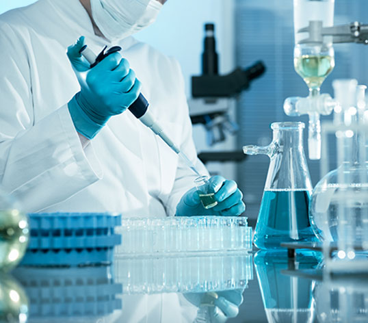 Eine Fachkraft arbeitet mit einer Pipette und untersucht Proben in einem modernen Labor.
