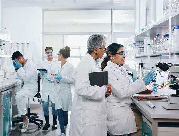 Mehrere Chemikerinnen und Chemiker arbeiten gemeinsam an Laborger&auml;ten und f&uuml;hren wissenschaftliche Untersuchungen durch.