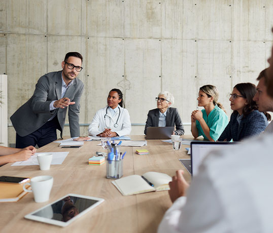 Fachkr&auml;fte aus Medizin und Management tauschen sich gemeinsam in einer Besprechung &uuml;ber Projekte und Arbeitsabl&auml;ufe aus.