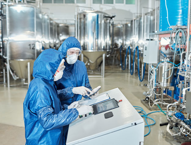 Zwei QC-Analysten &uuml;berwachen Produktionsanlagen und dokumentieren Qualit&auml;tskontrollen in einer pharmazeutischen Fertigung.