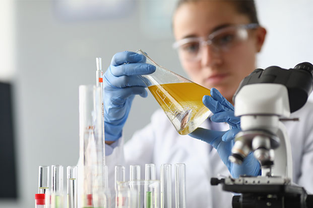 Eine Wissenschaftlerin untersucht eine Fl&uuml;ssigkeitsprobe im Labor und analysiert deren Zusammensetzung mithilfe moderner Labortechnik.