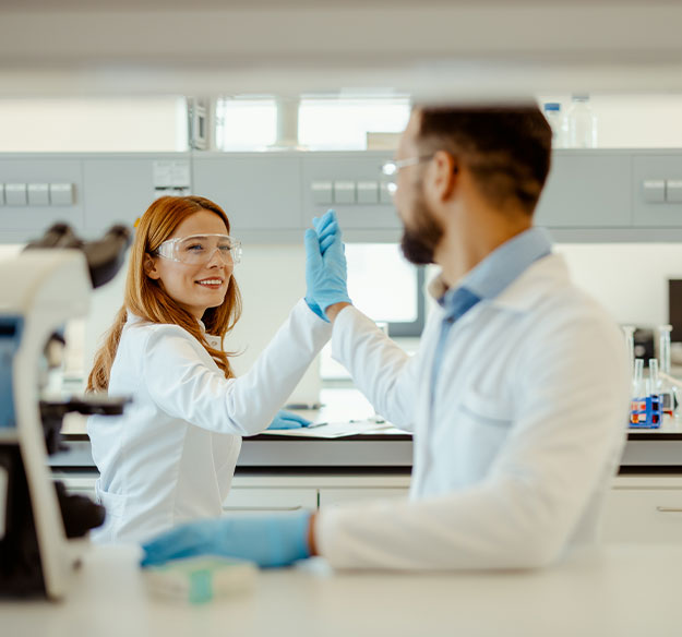 Zwei Laborfachkr&auml;fte feiern einen gemeinsamen Erfolg und stehen f&uuml;r Teamarbeit, Motivation und Freude an wissenschaftlicher Arbeit.