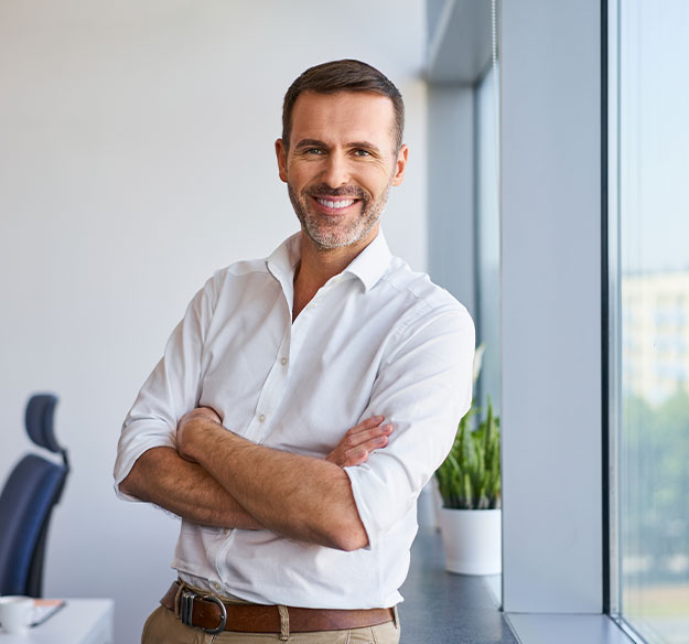 Ein selbstbewusster Mitarbeiter im modernen B&uuml;ro steht f&uuml;r Professionalit&auml;t, Erfahrung und eine erfolgreiche Zusammenarbeit auf Augenh&ouml;he.